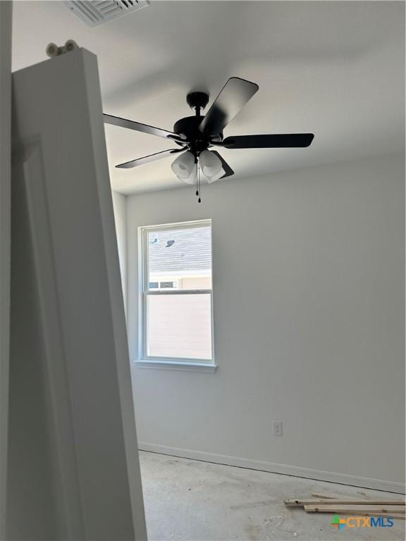 empty room featuring unfinished concrete floors, baseboards, a ceiling fan, and visible vents