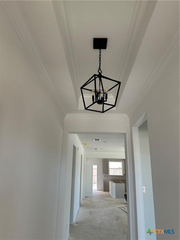 hall featuring ornamental molding and a chandelier
