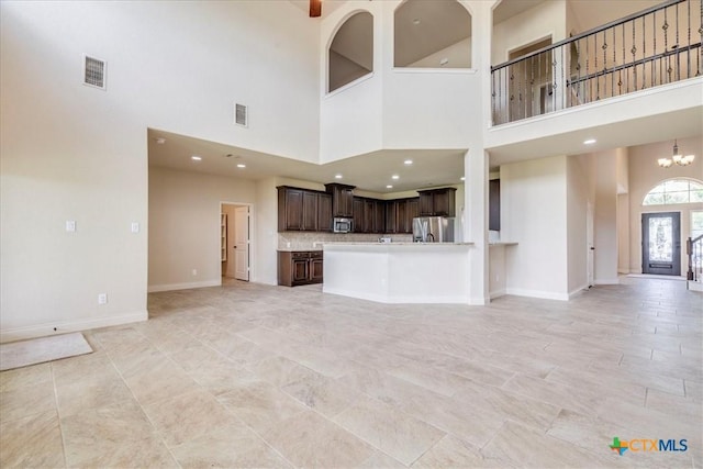 2933 Countryside Path, Seguin, TX 78155 - unfurnished living room featuring a towering ceiling, recessed lighting, a chandelier, and light tile patterned floors
