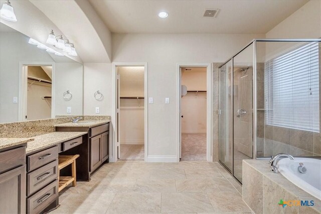 2933 Countryside Path, Seguin, TX 78155 - bathroom with vanity, a spacious closet, a bath, a stall shower, and recessed lighting