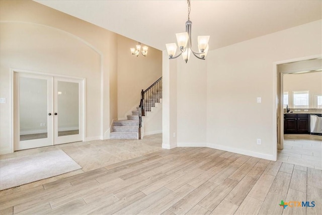 2933 Countryside Path, Seguin, TX 78155 - empty room featuring a chandelier, light wood-style floors, stairway, and french doors