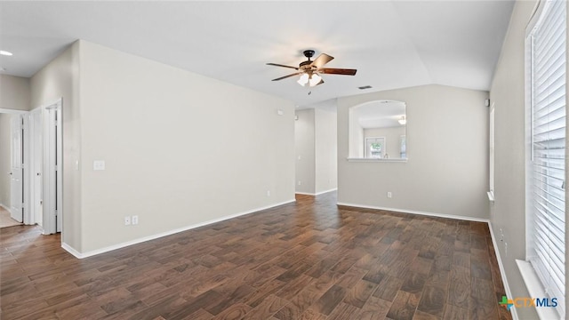 unfurnished room featuring baseboards, a ceiling fan, dark wood-style flooring, and arched walkways