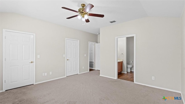 unfurnished bedroom with visible vents, baseboards, carpet floors, and vaulted ceiling