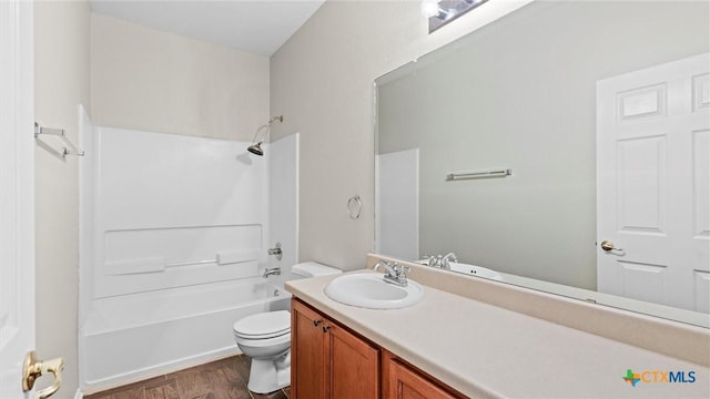 full bath featuring toilet,  shower combination, wood finished floors, and vanity