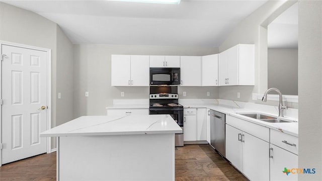 kitchen featuring light stone countertops, vaulted ceiling, a sink, stainless steel appliances, and white cabinetry