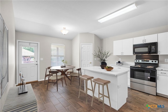 929 Darion St, New Braunfels, TX 78130 - kitchen featuring a center island, black microwave, vaulted ceiling, stainless steel range with electric stovetop, and light countertops