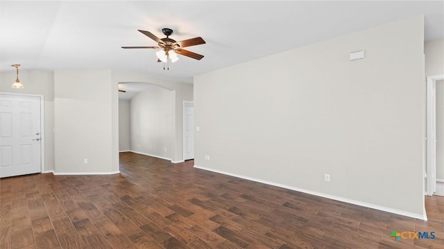 unfurnished living room with baseboards, arched walkways, ceiling fan, and wood finished floors