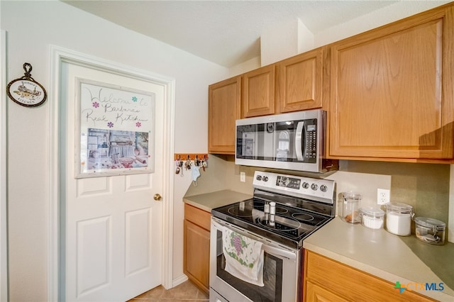 1495 Makinson Rd, La Grange, TX 78963 - kitchen featuring appliances with stainless steel finishes, light countertops, and light tile patterned flooring
