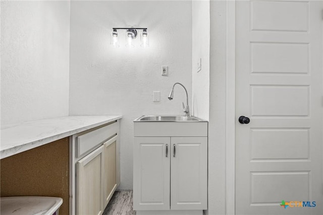 1213 Indian Trl, Salado, TX 76571 - bar area featuring a sink and light wood-style floors