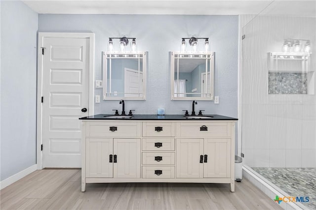1213 Indian Trl, Salado, TX 76571 - bathroom with double vanity, a tile shower, and wood finished floors