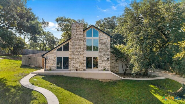 1213 Indian Trl, Salado, TX 76571 - back of property with stone siding, a lawn, a chimney, and a patio