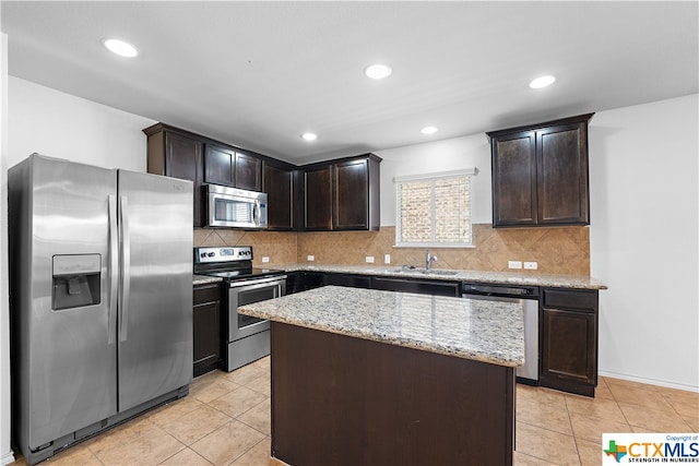 kitchen featuring backsplash, appliances with stainless steel finishes, dark brown cabinets, and a center island