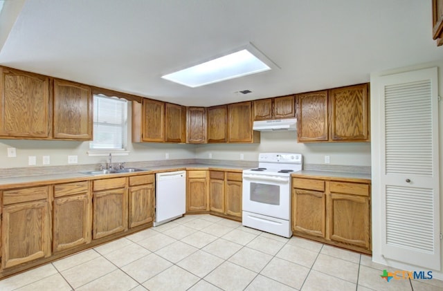 kitchen featuring white appliances, sink, and light tile patterned flooring