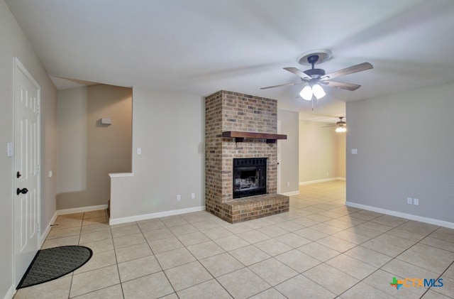 unfurnished living room with a brick fireplace, ceiling fan, and light tile patterned floors