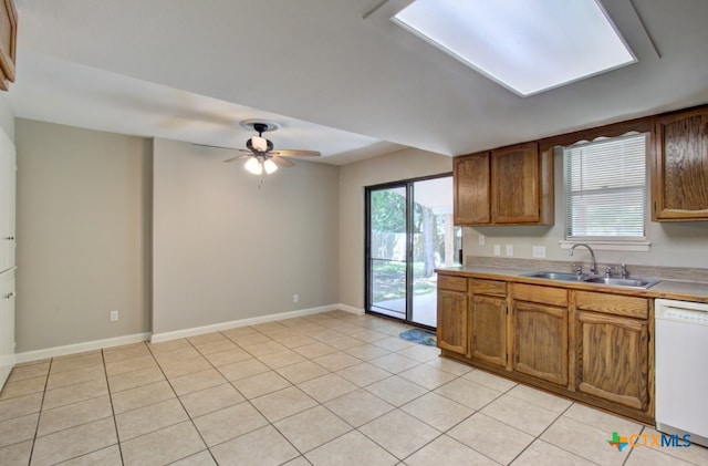 kitchen with white dishwasher, ceiling fan, light tile patterned floors, and sink