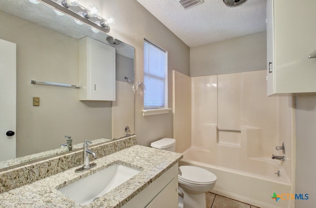 full bathroom featuring toilet, tile patterned flooring, a textured ceiling, vanity, and bathing tub / shower combination