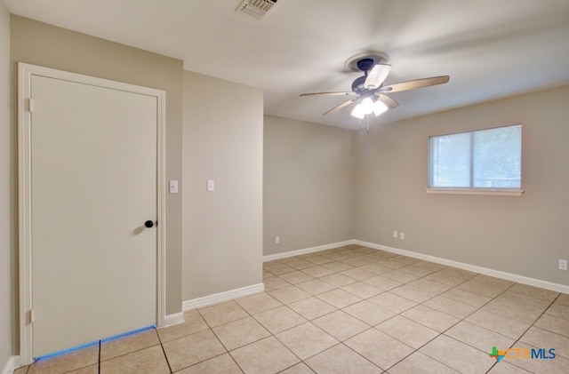 spare room with ceiling fan and light tile patterned floors