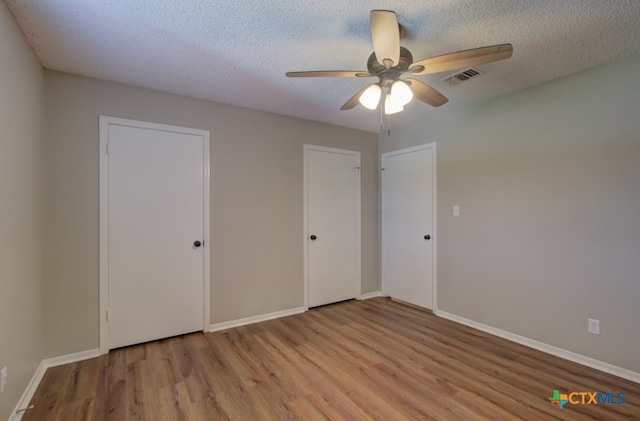 unfurnished bedroom featuring ceiling fan, a textured ceiling, and light wood-type flooring