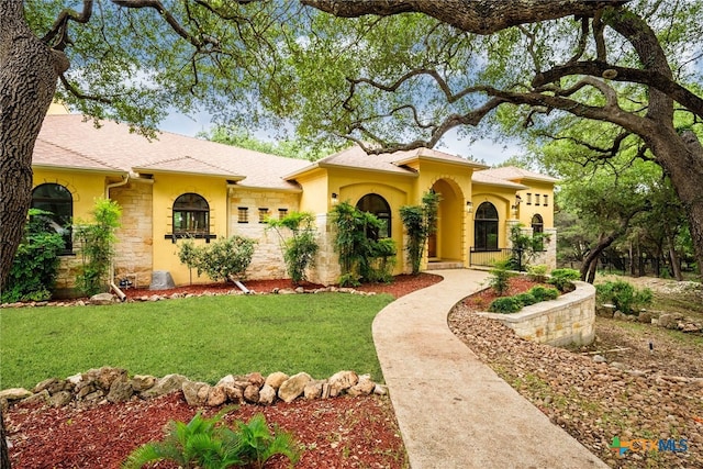 mediterranean / spanish house with a front lawn