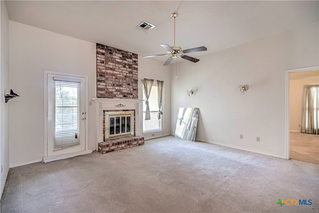 unfurnished living room with a brick fireplace, ceiling fan, plenty of natural light, and carpet floors