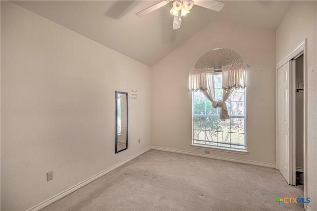 carpeted empty room with ceiling fan and lofted ceiling