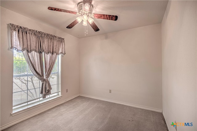 carpeted spare room with a wealth of natural light and ceiling fan