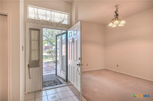 foyer featuring a notable chandelier and light carpet