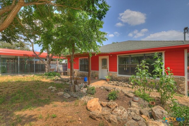 exterior space with stone siding and fence