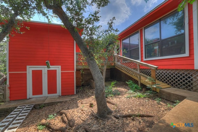 view of home's exterior featuring stairway, an outbuilding, and a shed