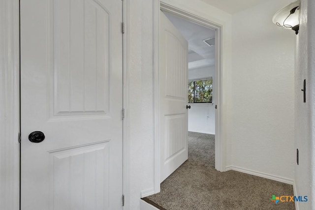 hallway featuring baseboards and carpet