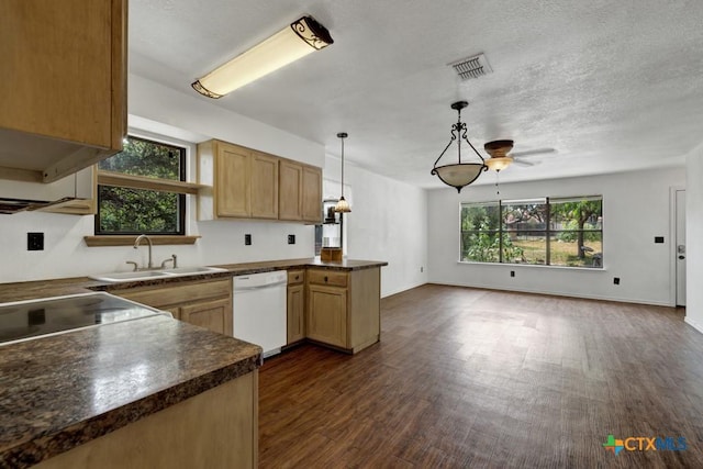 kitchen with visible vents, open floor plan, a peninsula, white dishwasher, and a sink