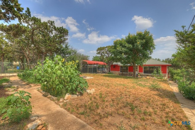 view of yard with a detached carport and fence