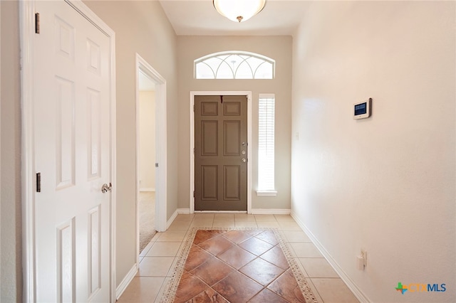 entryway with a wealth of natural light and light tile patterned floors