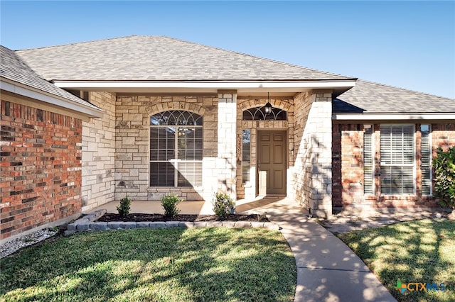 view of exterior entry with a yard