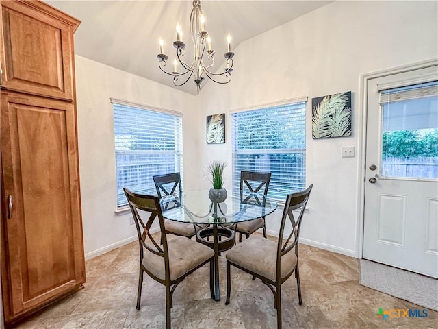 dining area with a notable chandelier, baseboards, and vaulted ceiling