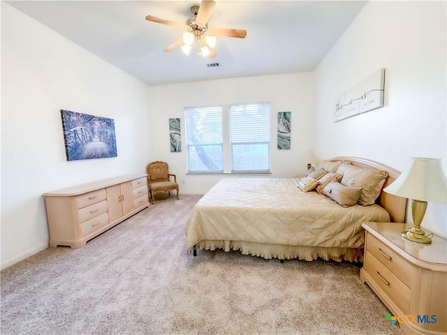 bedroom featuring visible vents, light colored carpet, and ceiling fan