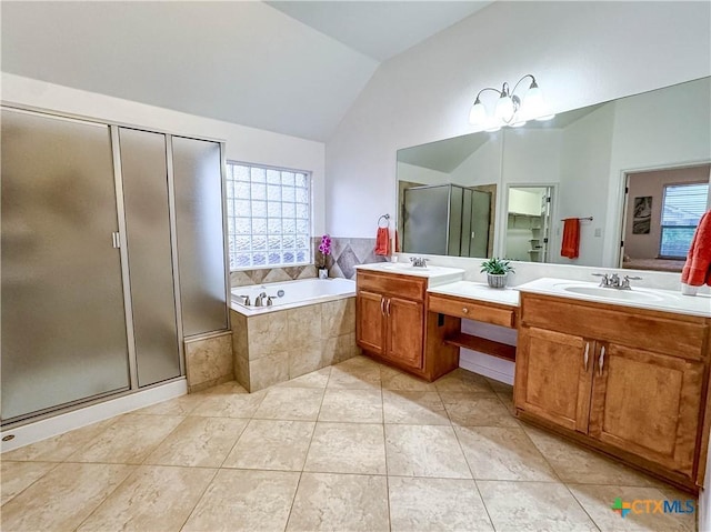 bathroom with double vanity, a stall shower, a sink, vaulted ceiling, and a garden tub