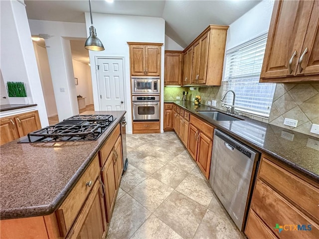 kitchen featuring brown cabinetry, appliances with stainless steel finishes, tasteful backsplash, and a sink