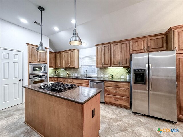 kitchen featuring visible vents, a sink, backsplash, appliances with stainless steel finishes, and lofted ceiling