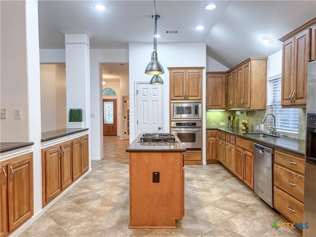 kitchen featuring a kitchen island, a sink, appliances with stainless steel finishes, dark countertops, and backsplash