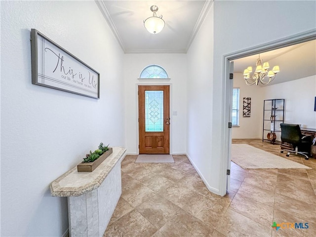 foyer entrance featuring crown molding, a wealth of natural light, and a chandelier