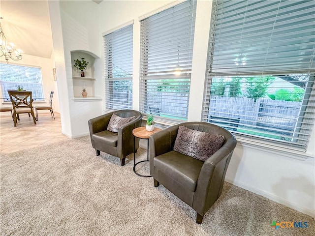 living area featuring tile patterned floors, carpet flooring, baseboards, and a chandelier