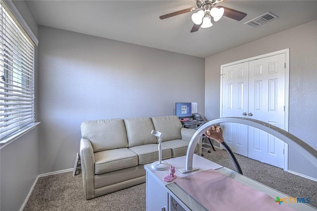 carpeted living room featuring ceiling fan