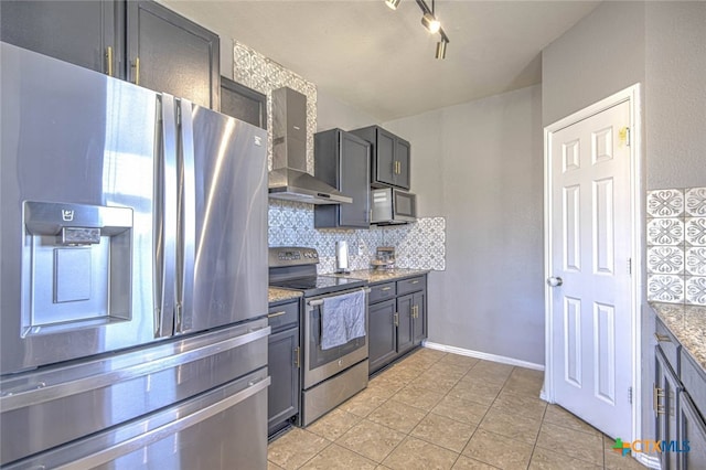 kitchen with light stone counters, light tile patterned flooring, stainless steel appliances, wall chimney range hood, and tasteful backsplash