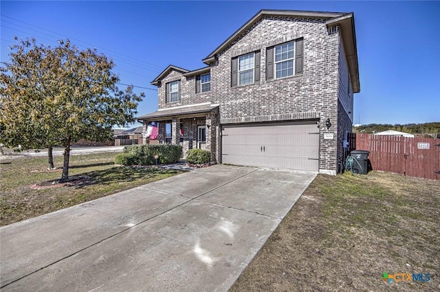 traditional-style home featuring a front lawn, driveway, fence, a garage, and brick siding