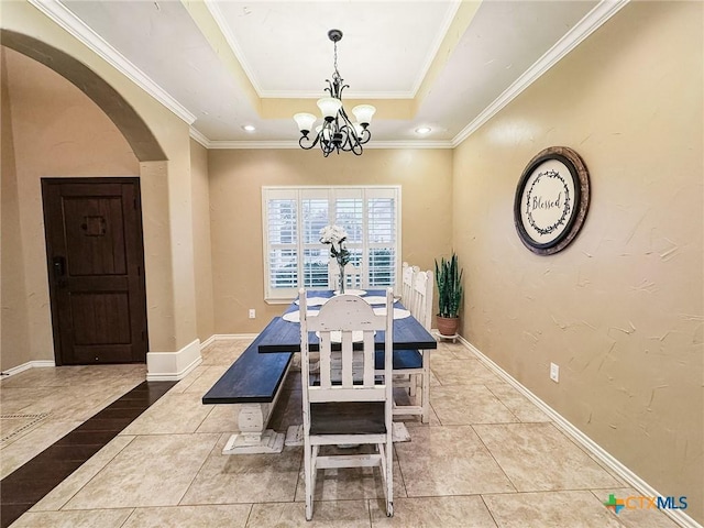 dining room with an inviting chandelier, light tile patterned floors, ornamental molding, and a raised ceiling