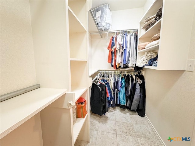 walk in closet featuring light tile patterned flooring