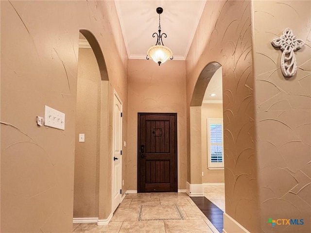 foyer featuring tile patterned floors and ornamental molding