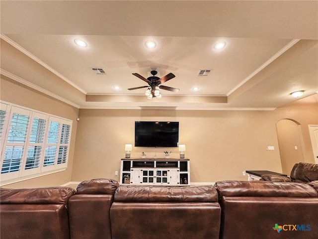 living room featuring crown molding, ceiling fan, and a tray ceiling