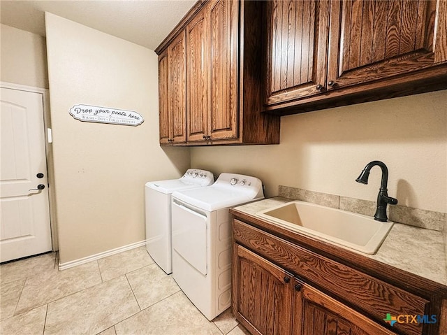 washroom with sink, washer and clothes dryer, cabinets, and light tile patterned flooring